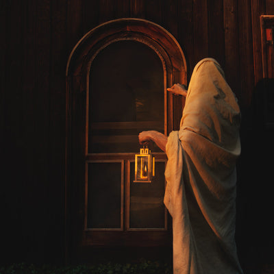 Christ standing in the night knocking on a door.