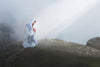 Jesus kneeling in prayer alone on a rock.